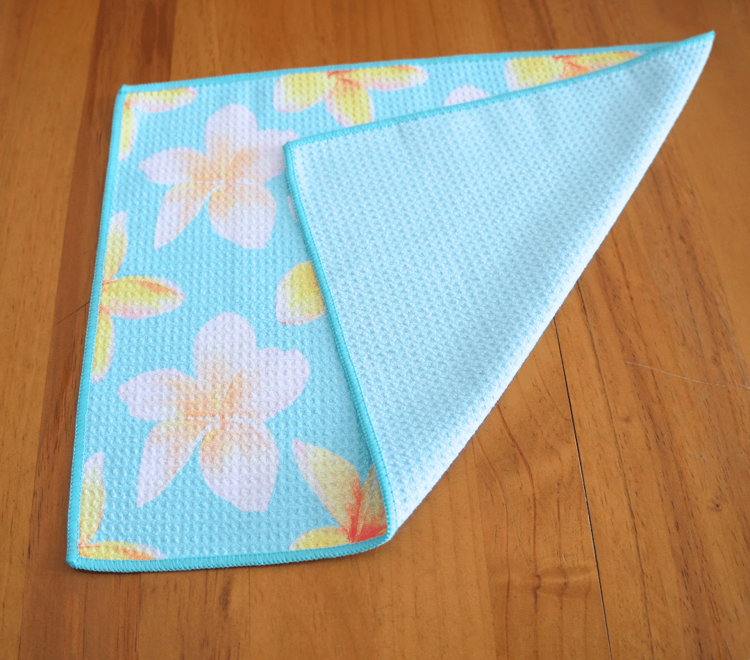 Folded DirtyGirl Frangipani Breeze Cloth displayed on bench – Reusable and eco-friendly