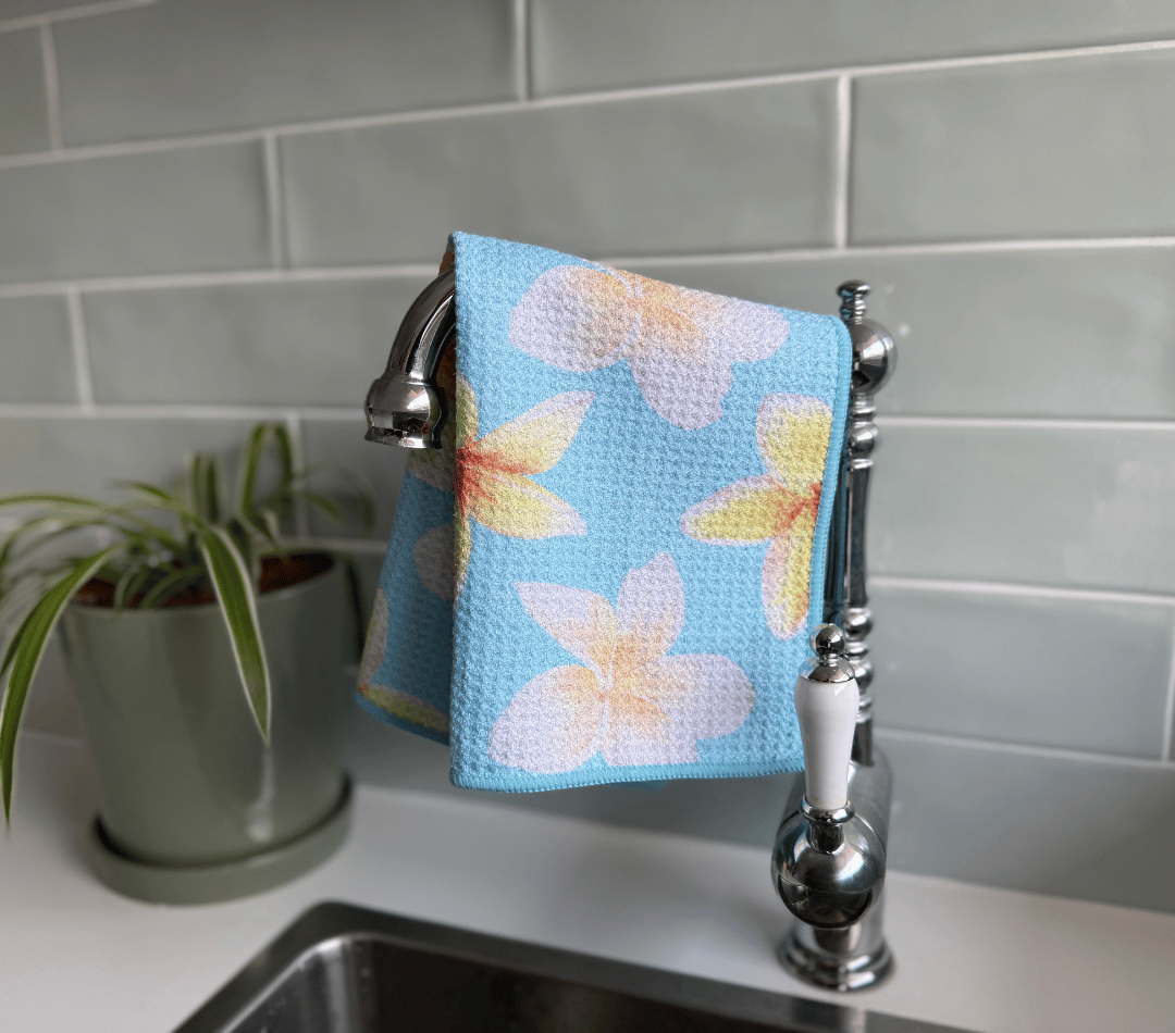 DirtyGirl Frangipani Breeze Cloth draped over sink tap – Absorbent weave for spills