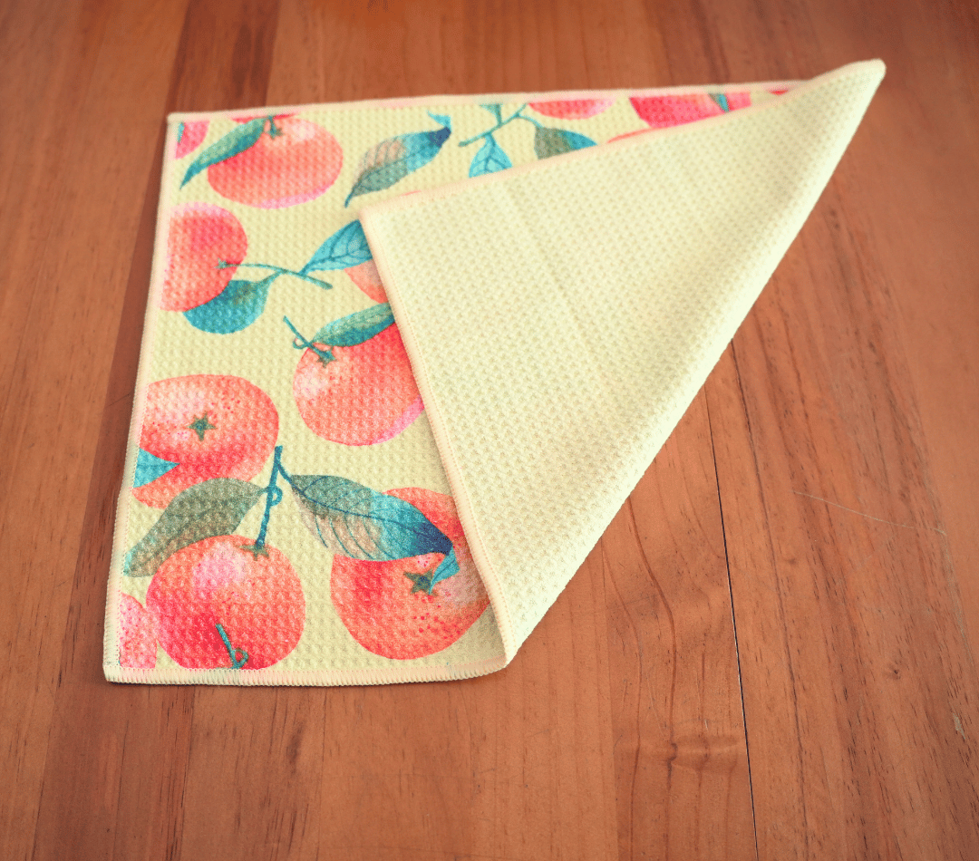 Folded DirtyGirl Orange Zest Cloth displayed on bench – Reusable and eco-friendly