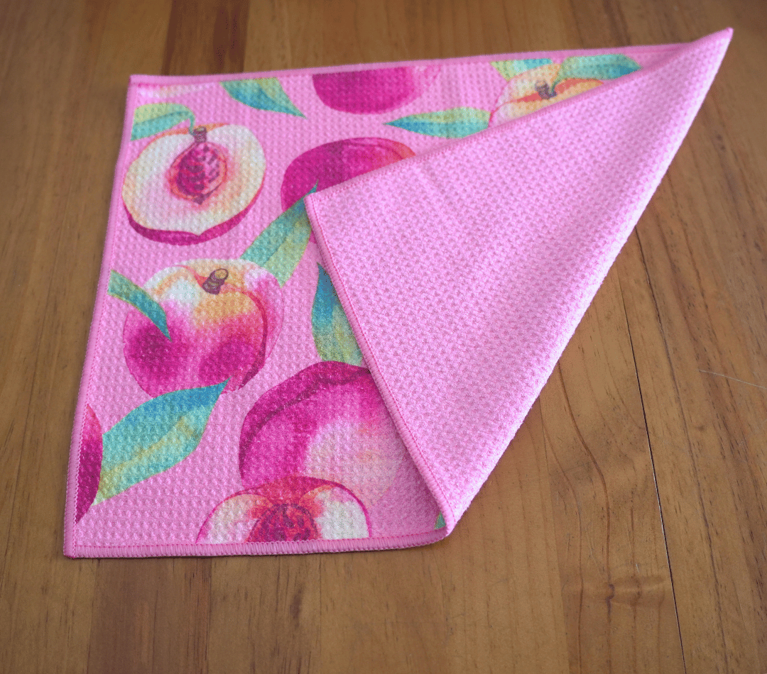 Folded DirtyGirl Peachy Clean Cloth displayed on bench – Reusable and eco-friendly