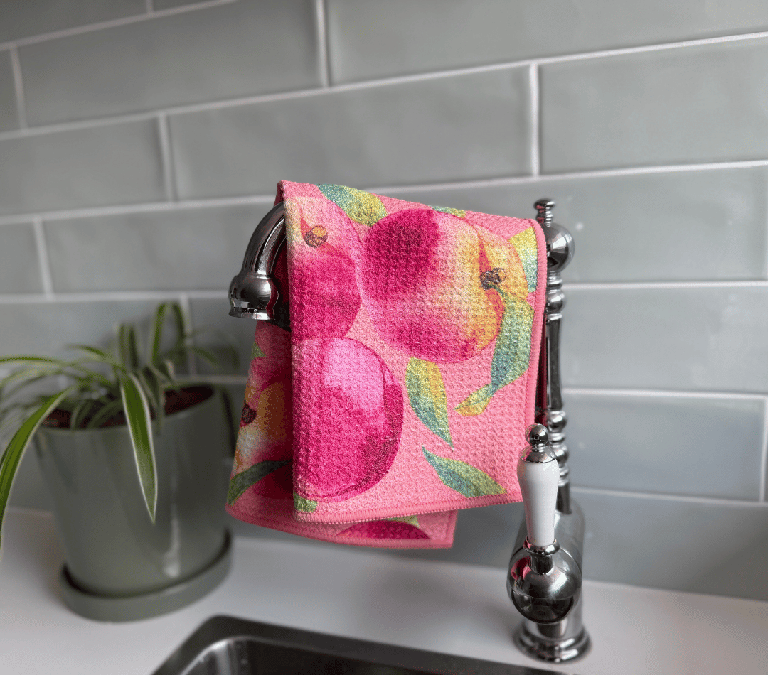 DirtyGirl Peachy Clean Cloth draped over sink tap – Absorbent weave for spills