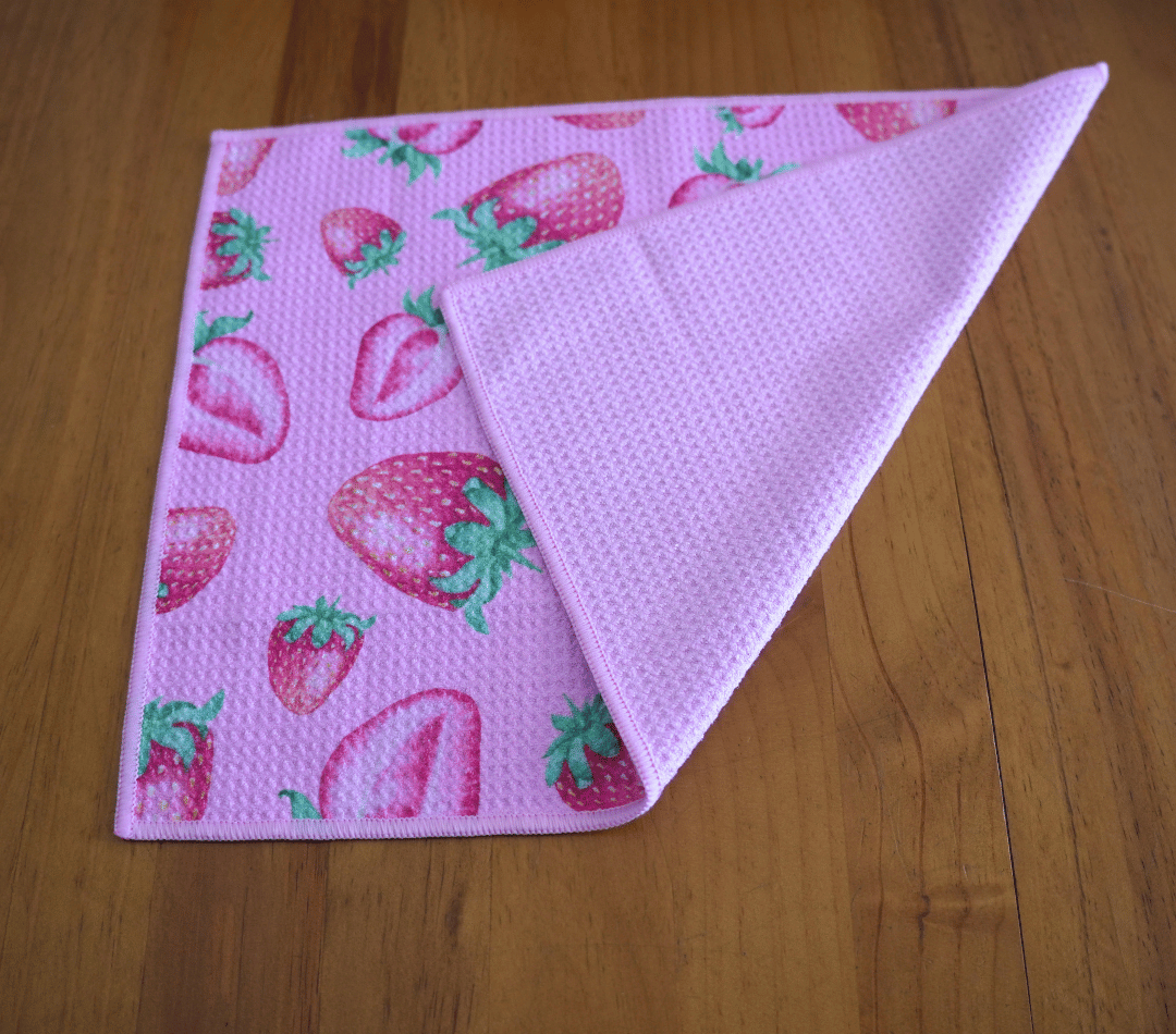 Folded DirtyGirl Strawberry Kiss Cloth displayed on bench – Reusable and eco-friendly