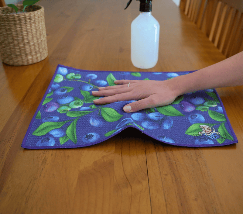 Hand wiping kitchen surface with DirtyGirl Berry Fresh Cloth – Lint-free finish