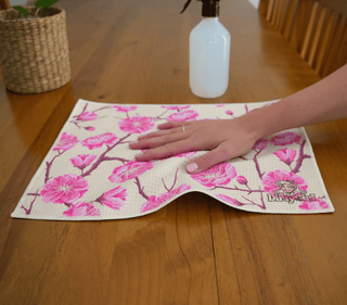 Hand wiping kitchen surface with DirtyGirl Blossom Bloom Cloth – Lint-free finish