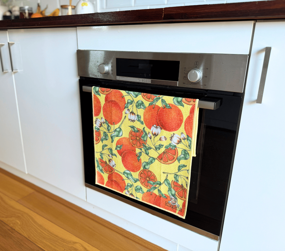 DirtyGirl Tangerine Dream Tea Towel folded neatly over oven handle – Machine washable